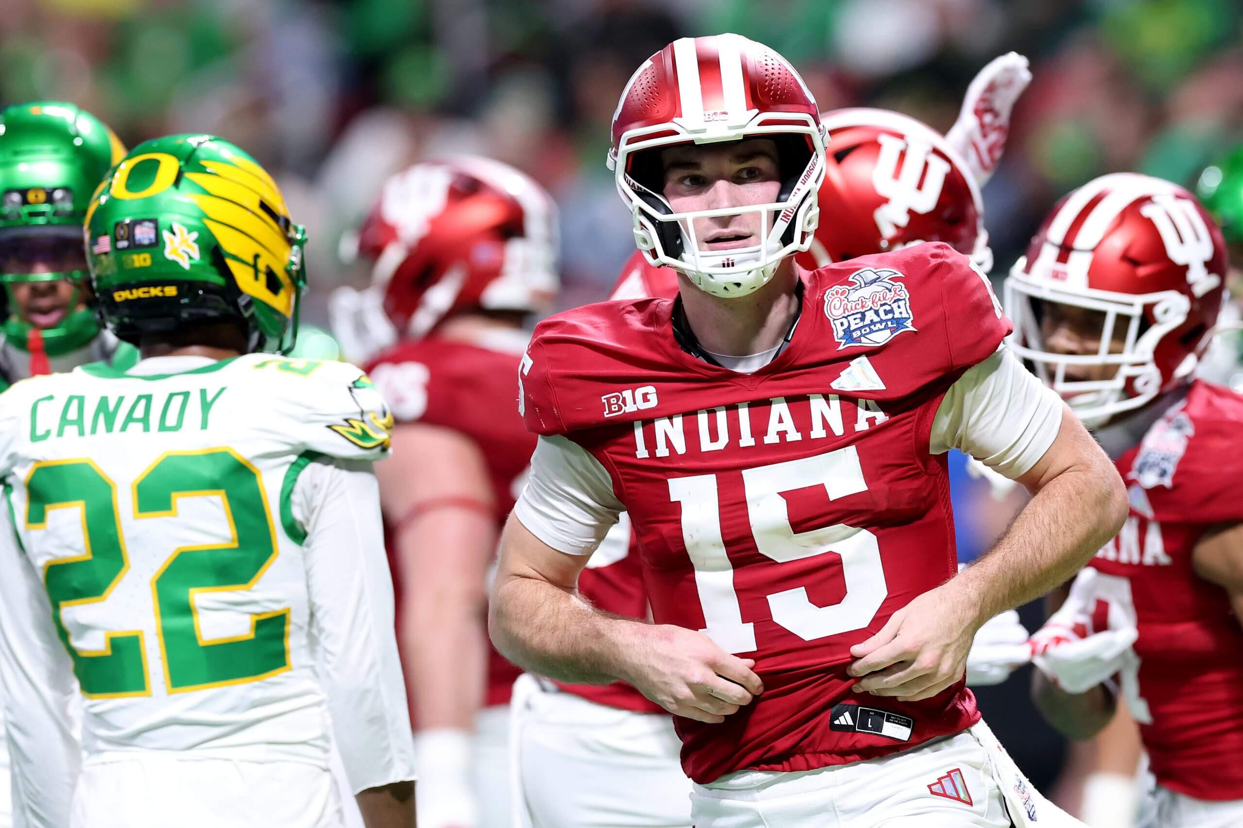 Indiana quarterback Fernando Mendoza reacts after a play with Oregon and Indiana players in the background