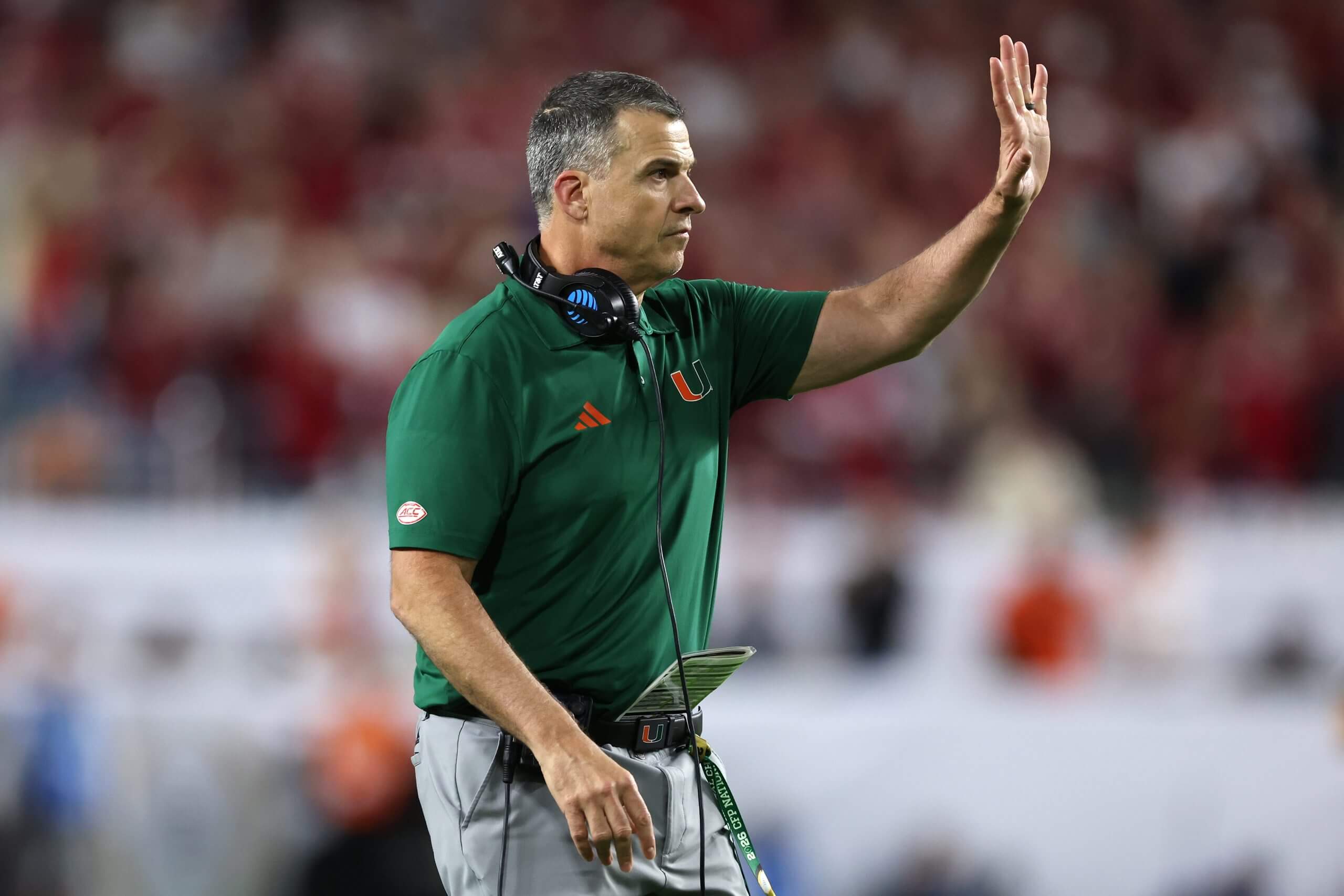 Miami coach Mario Cristobal holds his left hand up with his headset around his neck during the national championship gmae