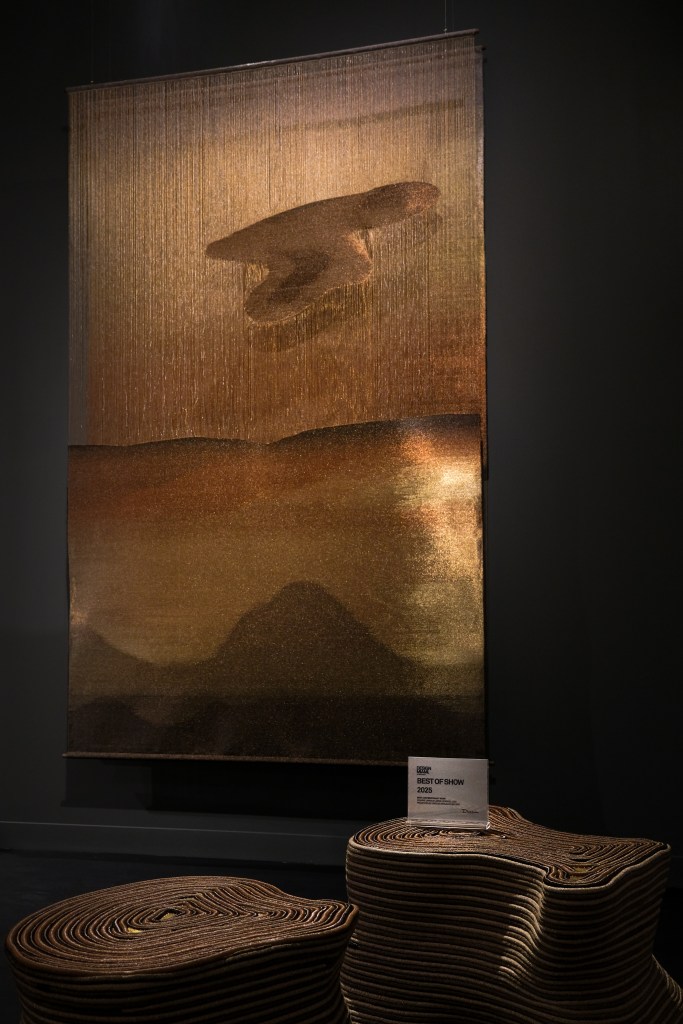 Jorge Lizarazo’s stunning wall hanging Japanese Sunrise featuring luminous, coppery fibers, inspired by a sunrise.