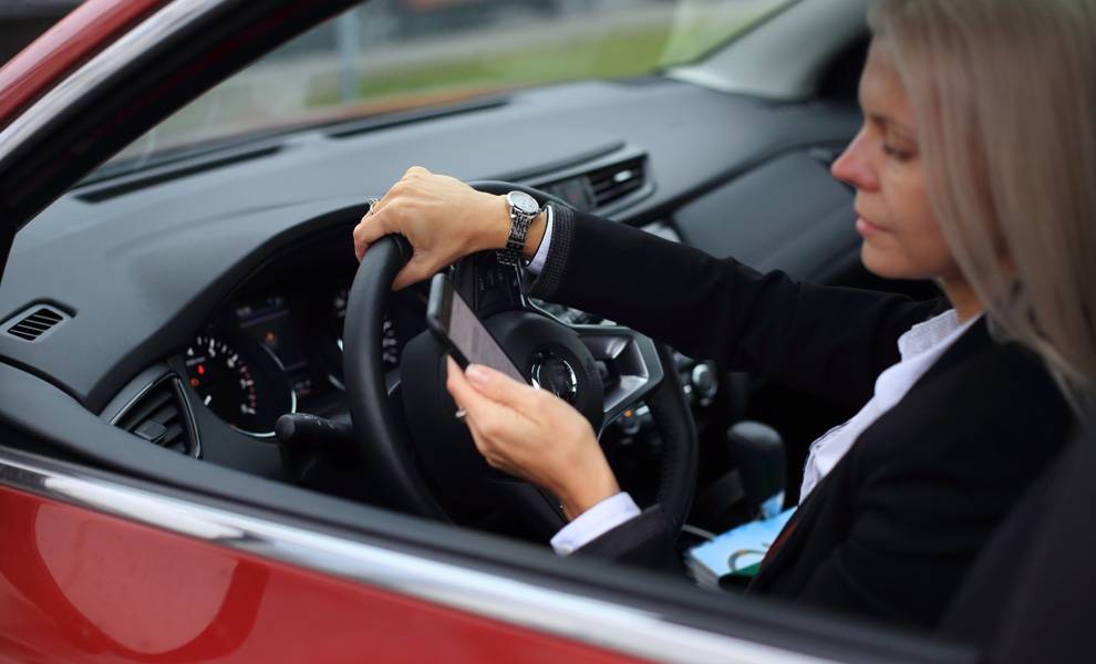 Florida’s new Hands-Free Driving Bill could change the way Miami moves 2 A woman in a red car using her cell phone while driving.