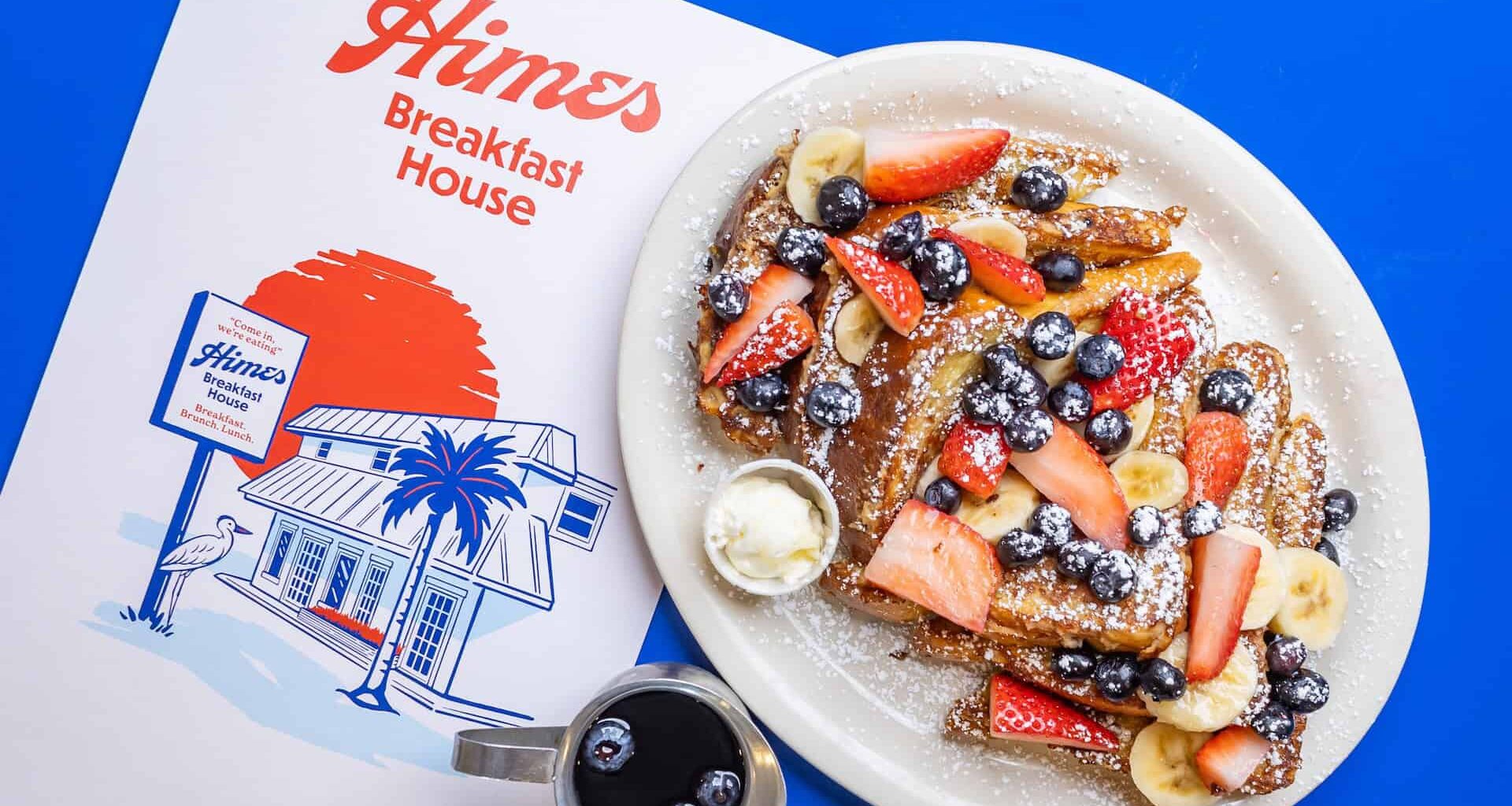 Aerial view of a plate of french toast and a menu that says Himes on the front