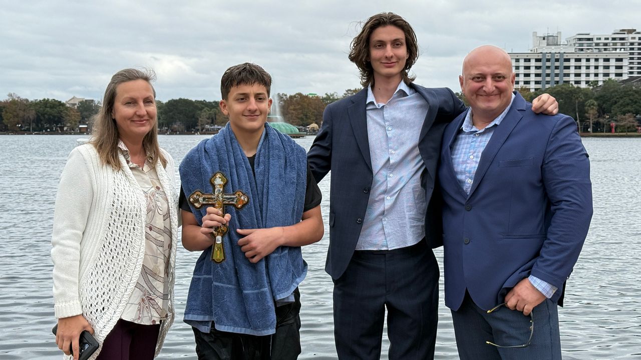 14-year-old Jason Gogsadze dove into Lake Eola and found the gold cross, receiving a special blessing from his church, St. George Orthodox Church. (Spectrum News/Emma Delamo)