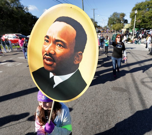 Marching in the 2022 Martin Luther King Jr. Commemoration Parade in Sanford, a student from Goldsboro Elementary Magnet School carries a placard of MLK. (Joe Burbank/Orlando Sentinel)