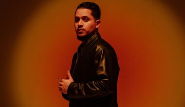 Portrait of a man wearing black against a red background.