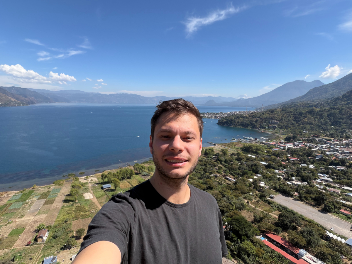 A man taking a selfie above a landscape.