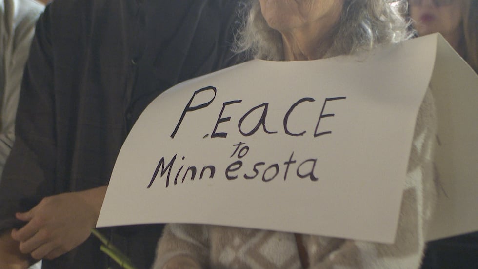 A protester holds a sign that says "peace to Minnesota" Thursday evening. 