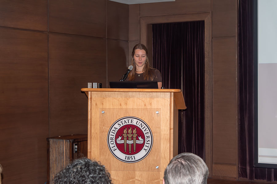 Leona Rindle, a senior at FSU studying psychology and human rights and social justice, delivers opening remarks at the podium during a graduation ceremony for the Global Citizenship Certificate (GCC).