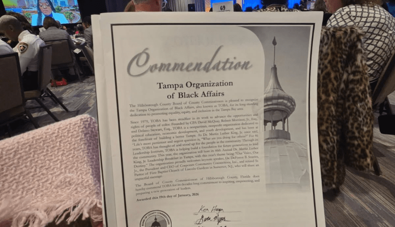 A close-up photograph of a formal "Commendation" document from the Hillsborough County Board of County Commissioners awarded to the Tampa Organization of Black Affairs (TOBA). The document, awarded on January 19, 2026, features a grayscale image of a minaret on the right side.