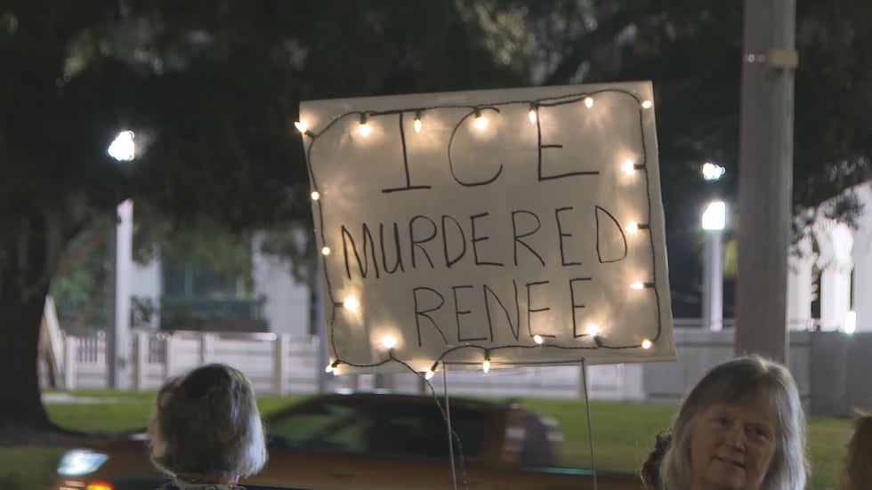 A protester holds a sign that says "ICE murdered Renee" at a demonstration in Tallahassee...