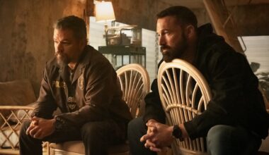 film still of Matt Damon and Ben Affleck dressed as detectives sitting on chairs