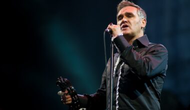 Photo of Morrissey performing on stage wearing a black shirt.