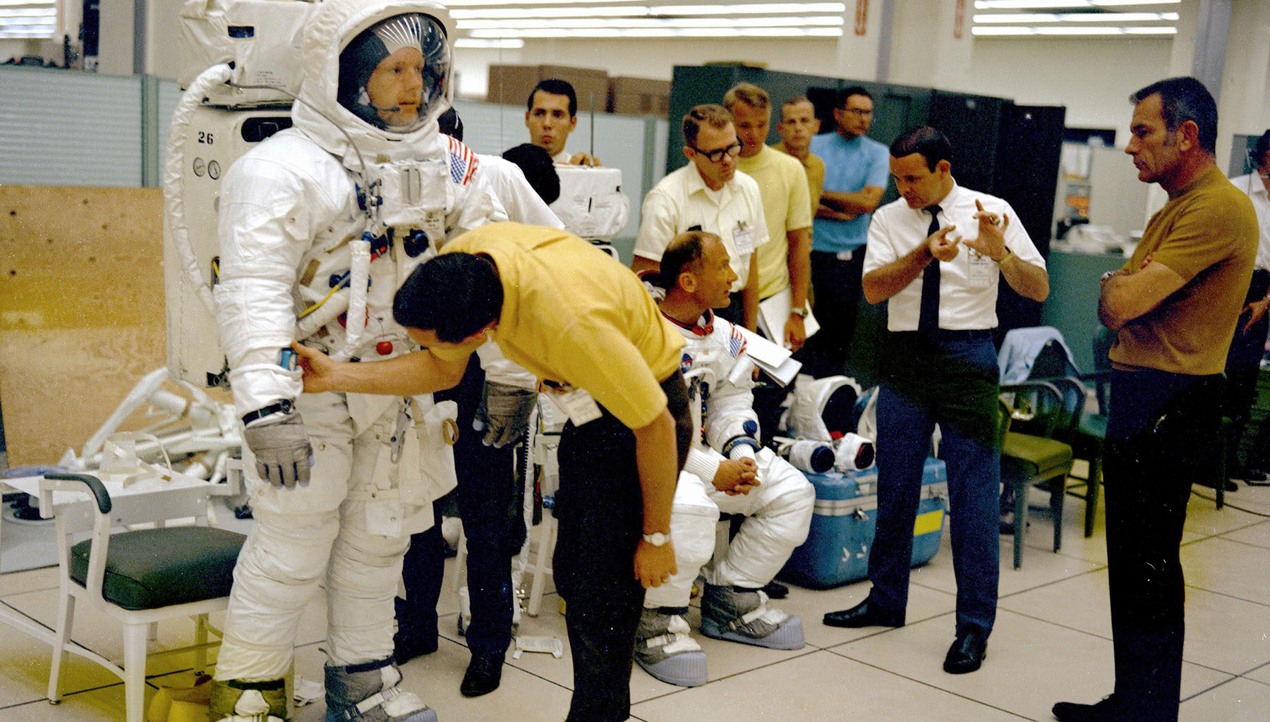 The Apollo 11 flight crew are given instructions by technicians and management while undergoing the Extravehicular Activity (EVA) training and the Lunar Module walk-through in preparation for the first manned landing on the Moon. (NASA)