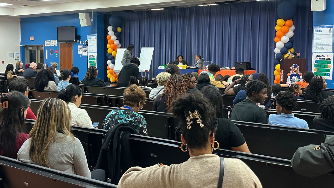 More than two dozen families and staff from Orange Center Elementary School filled into the school's cafeteria Thursday to hear the results of a vote on a plan to turn their school into a public-private charter school. (Spectrum News/Brandon Spencer)