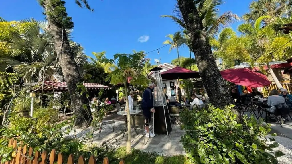 outdoor dining patio with red tents, and palm trees