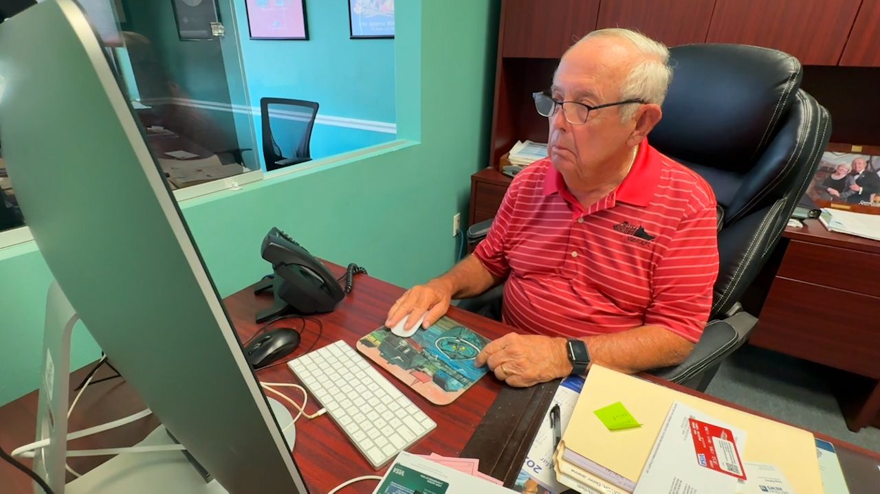 Larry Jackson of Cruise Holidays in Viera searches for bookings. (Spectrum News/Greg Pallone)
