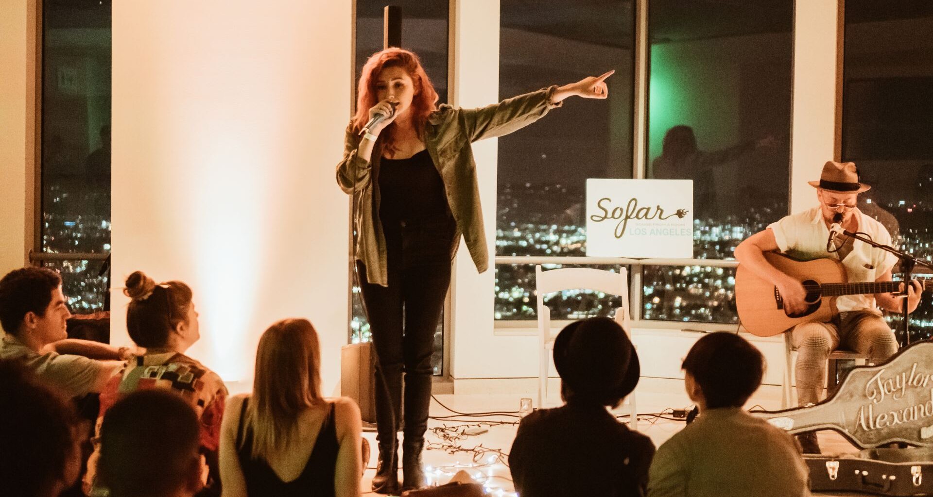 Photo of a woman singing on a microphone on a stage.