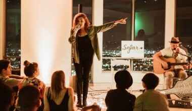 Photo of a woman singing on a microphone on a stage.
