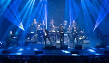 An orchestra on stage under blue lights
