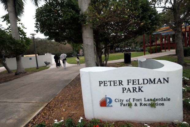 A family walks past the sewer lift station at Peter Feldman Park in Fort Lauderdale on Thursday. Fort Lauderdale officials want to build another sewage lift station in a nearby park that has yet to be built. (Amy Beth Bennett/South Florida Sun Sentinel)