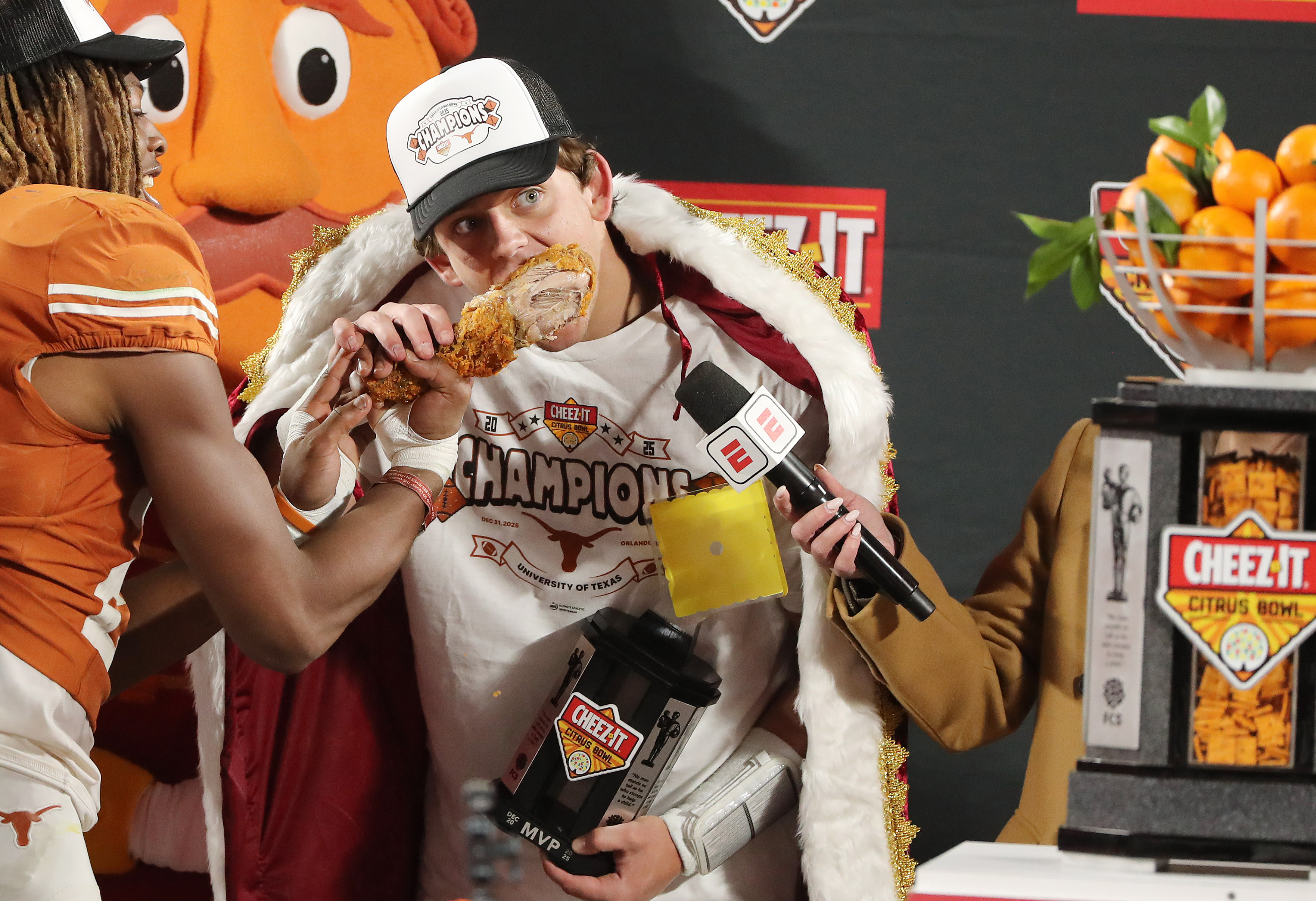 Texas quarterback Arch Manning takes a bite of a turkey...
