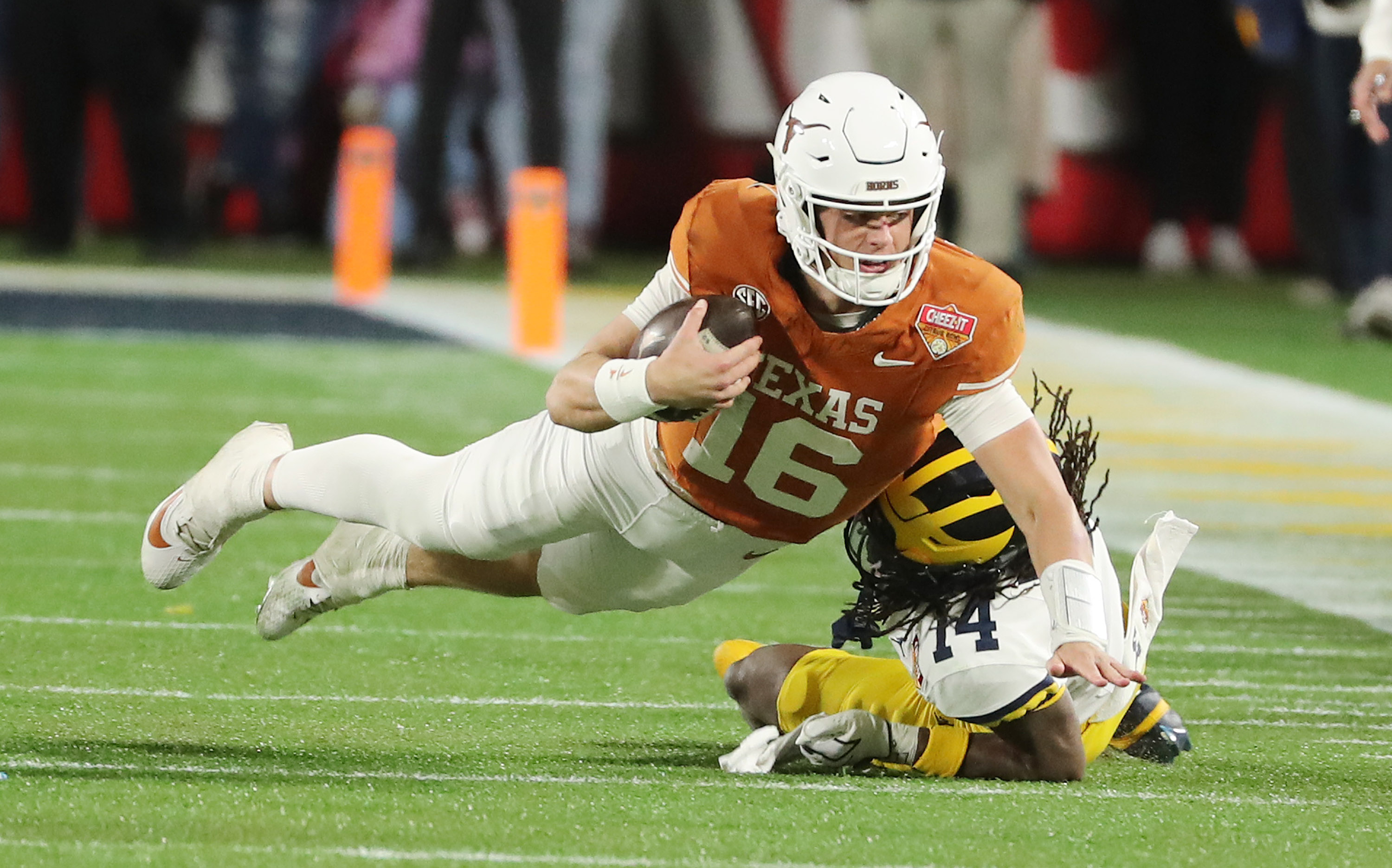 Texas quarterbackk Arch Manning (16) leaps for extra yardage over...