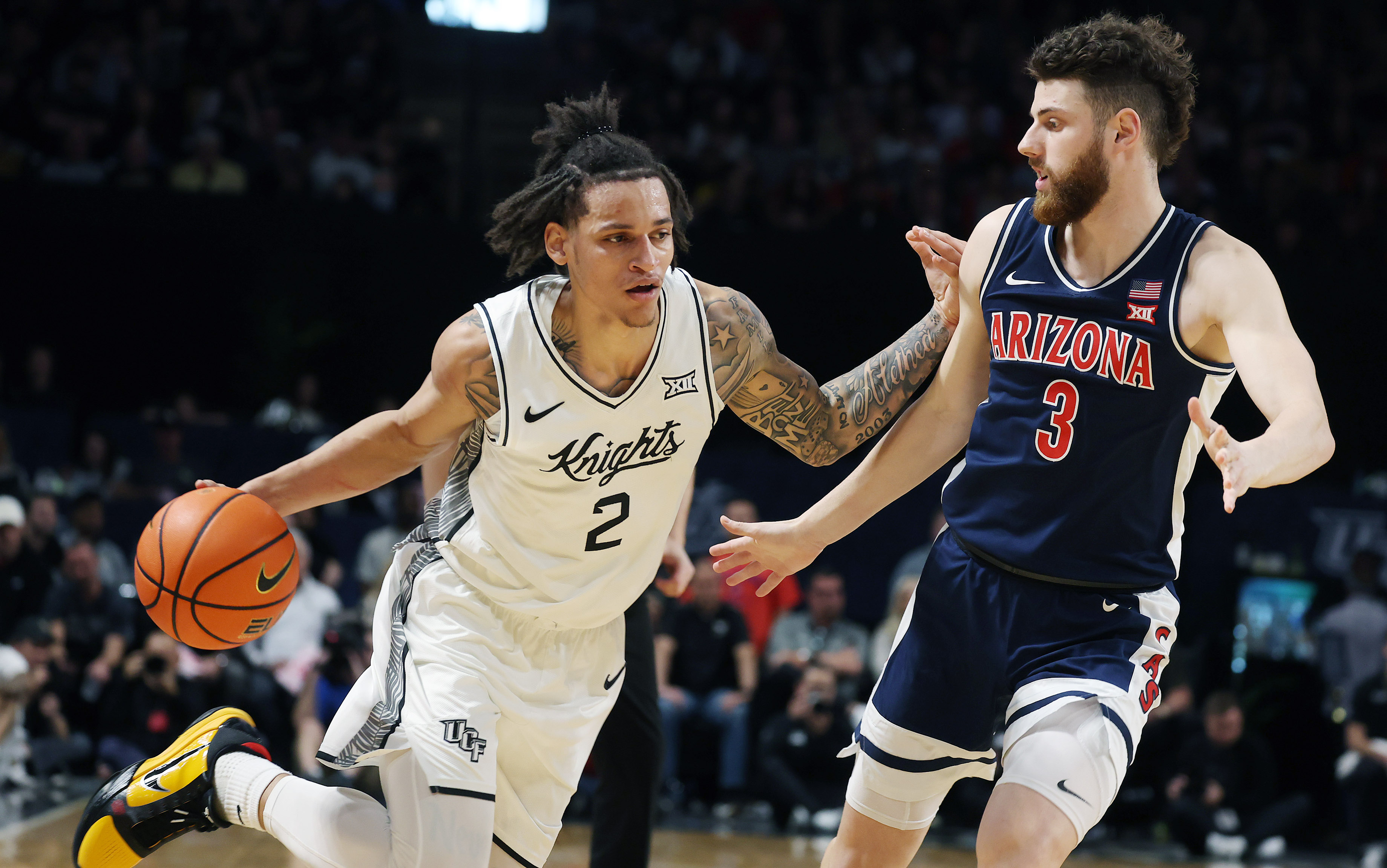 UCF guard Riley Kugel (2) drives past Arizona guard Anthony...