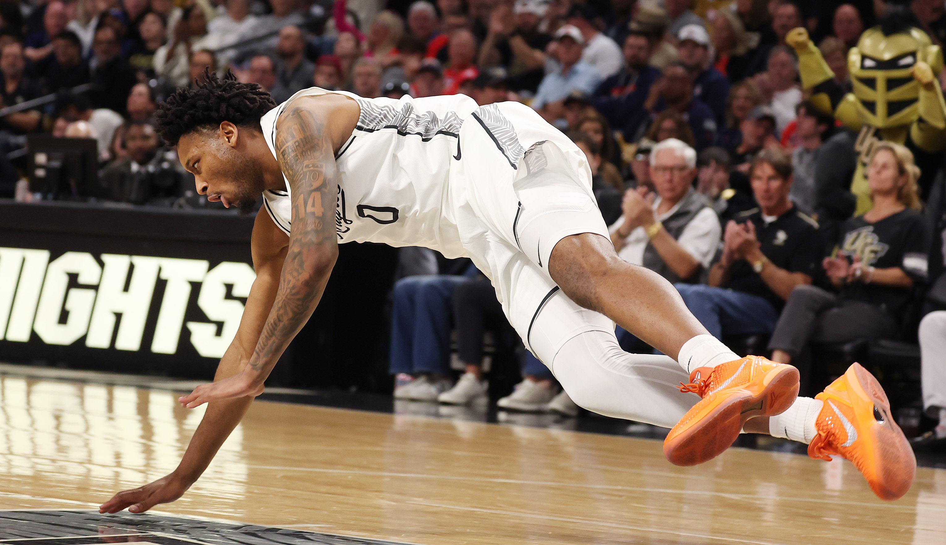 UCF center Jeremy Foumena takes a fall during the Arizona...