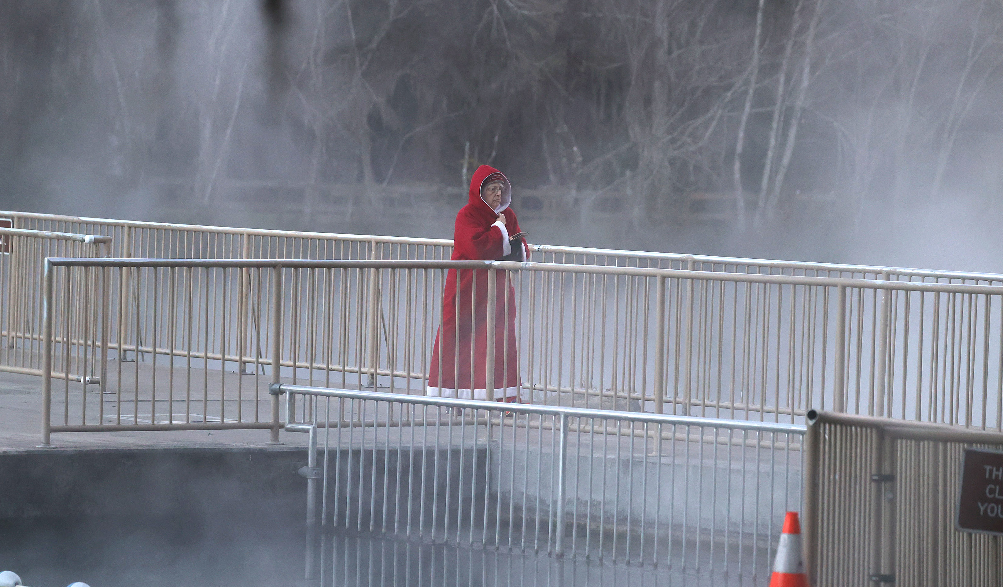 A lone swimmer, dressed in holiday garb, walks across a...
