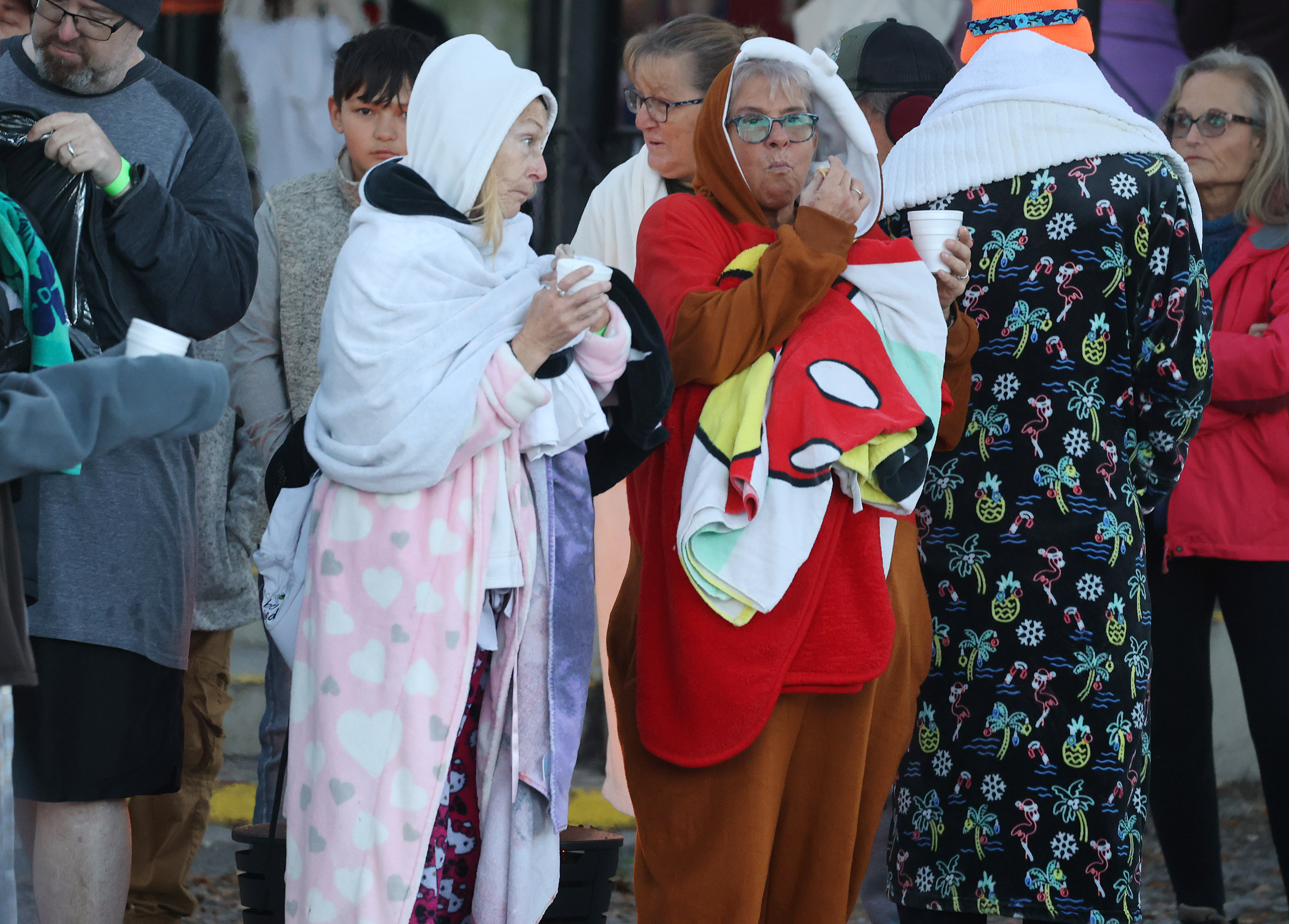 Dressed warmly, swimmers wait in the 32-degree weather to leap...