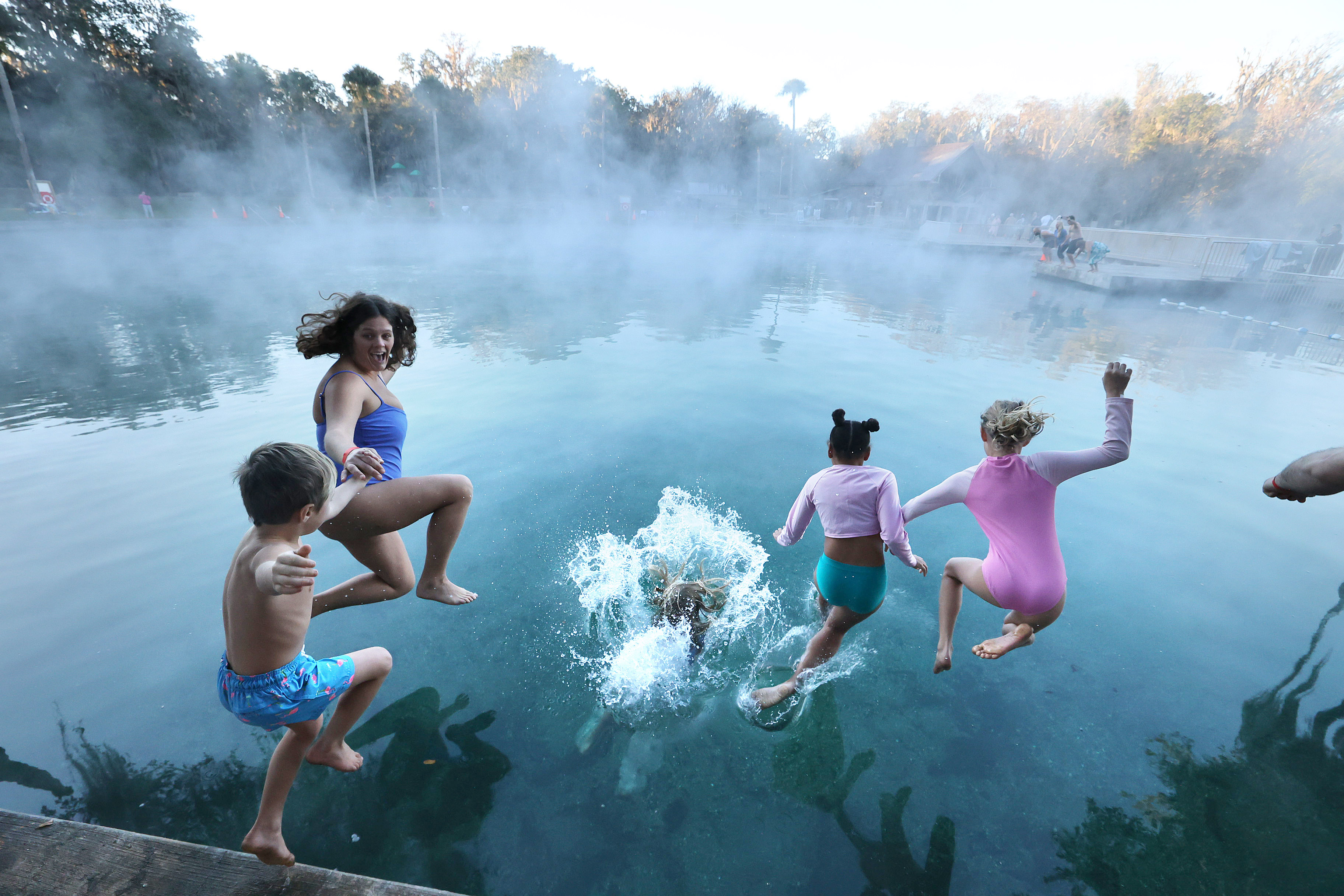 A family braves the 32-degree weather to leap into the...