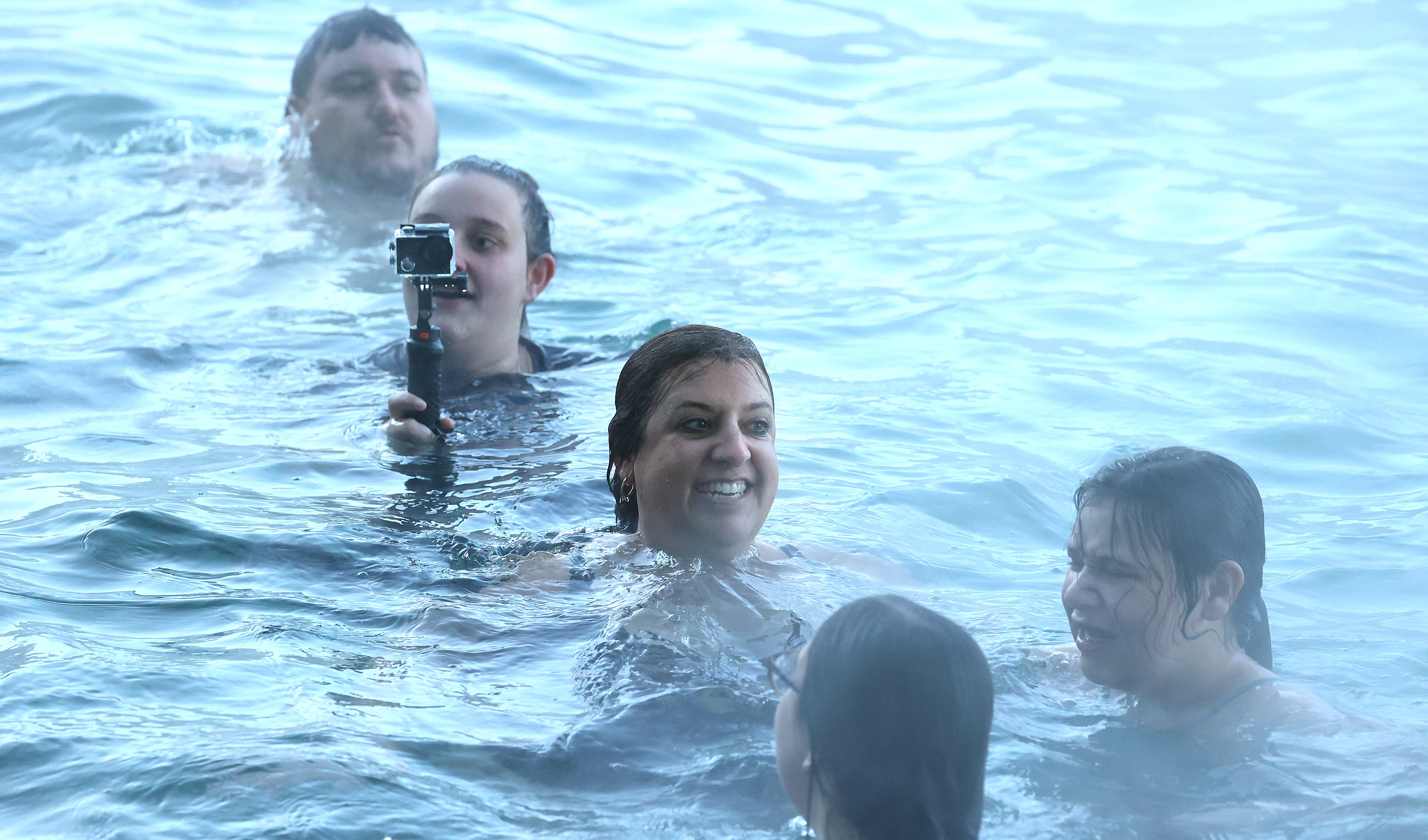 Swimmers smile after braving the 32-degree weather to leap into...