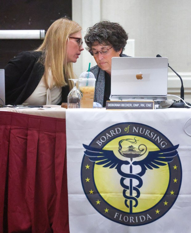 Jessica Nijem, Chief of Health Care Practitioner Regulation for the Florida Department of Health, left, confers with Florida Board of Nursing chair Dr. Deborah Becker during a meeting of the board in Maitland, Dec. 5, 2025. "If we could have been checking on these schools, I feel like we could have prevented some of this, possibly," Becker said in a meeting a year earlier. (Joe Burbank/Orlando Sentinel)
