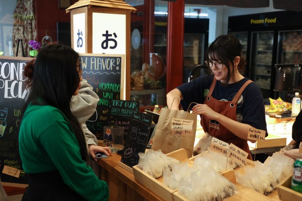 Customers at Mills Market order from a selection of nori-wrapped rice balls at UniGirl inside Mills Market. The market shared Restaurant of the Year honors with Sorekara in the 2025 Orlando Sentinel Foodie Awards. (Rich Pope, Orlando Sentinel)