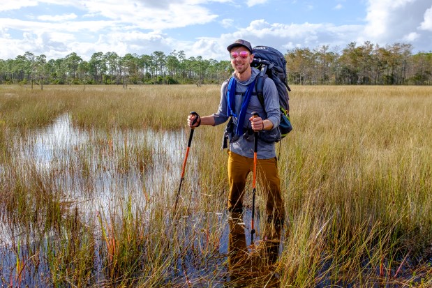 Patrick Connolly stands in knee-deep water while getting to a secluded island campsite during a backpacking trip on the Ocean to Lake Hiking Trail on Nov. 2, 2024. (Patrick Connolly/Orlando Sentinel)
