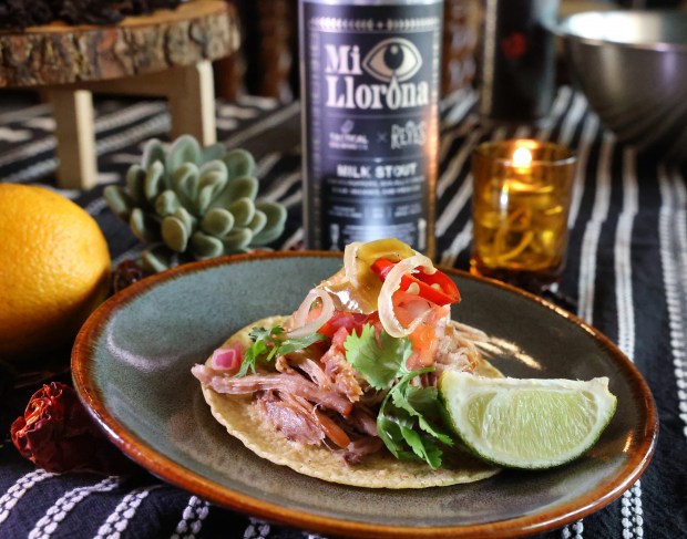 A Mi Llorona beer, a small-batch collaboration between Reyes Mezcaleria and Tactical Brewing of Orlando, is featured with a carnitas pulled-pork taco at the restaurant, Tuesday, Sept. 16, 2025. (Joe Burbank/Orlando Sentinel)