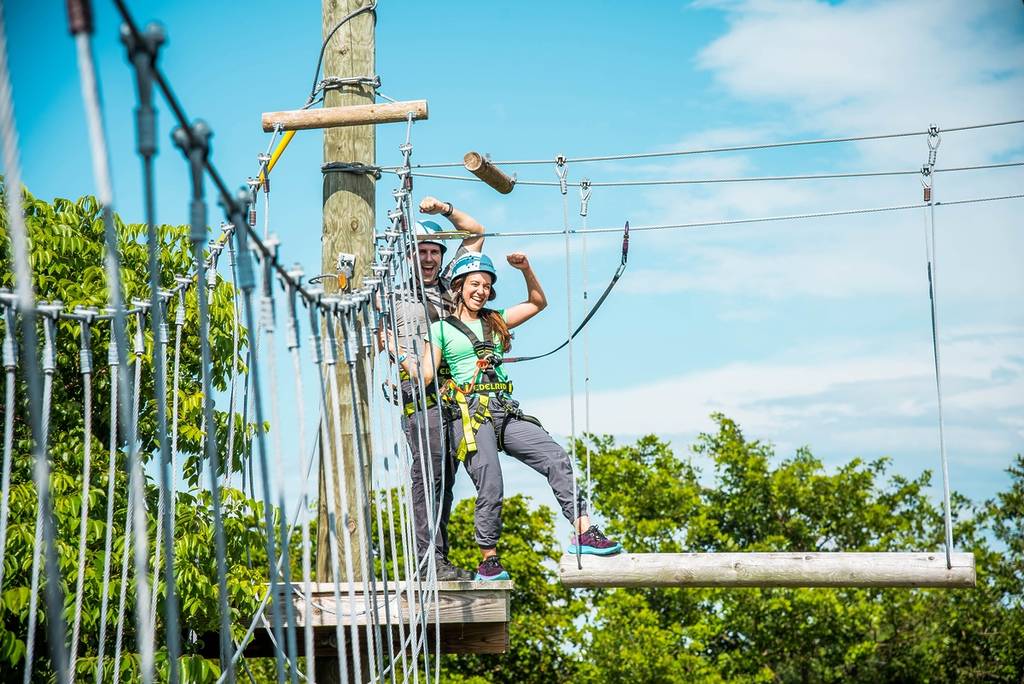 Couple posing atop the trees at Treetop Trekking