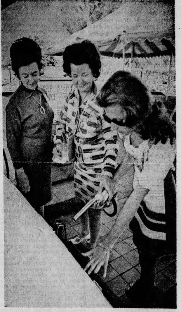 Dottie Thornton, with nozzle, shows Nell Vickers, left, and Nell Cole, that it no longer takes a man's hand to gas up the car during demonstration of dealer Robert Hughes's new self-service gas station, The Gas Garden, 4255 W. Colonial Drive. (Sentinel file)