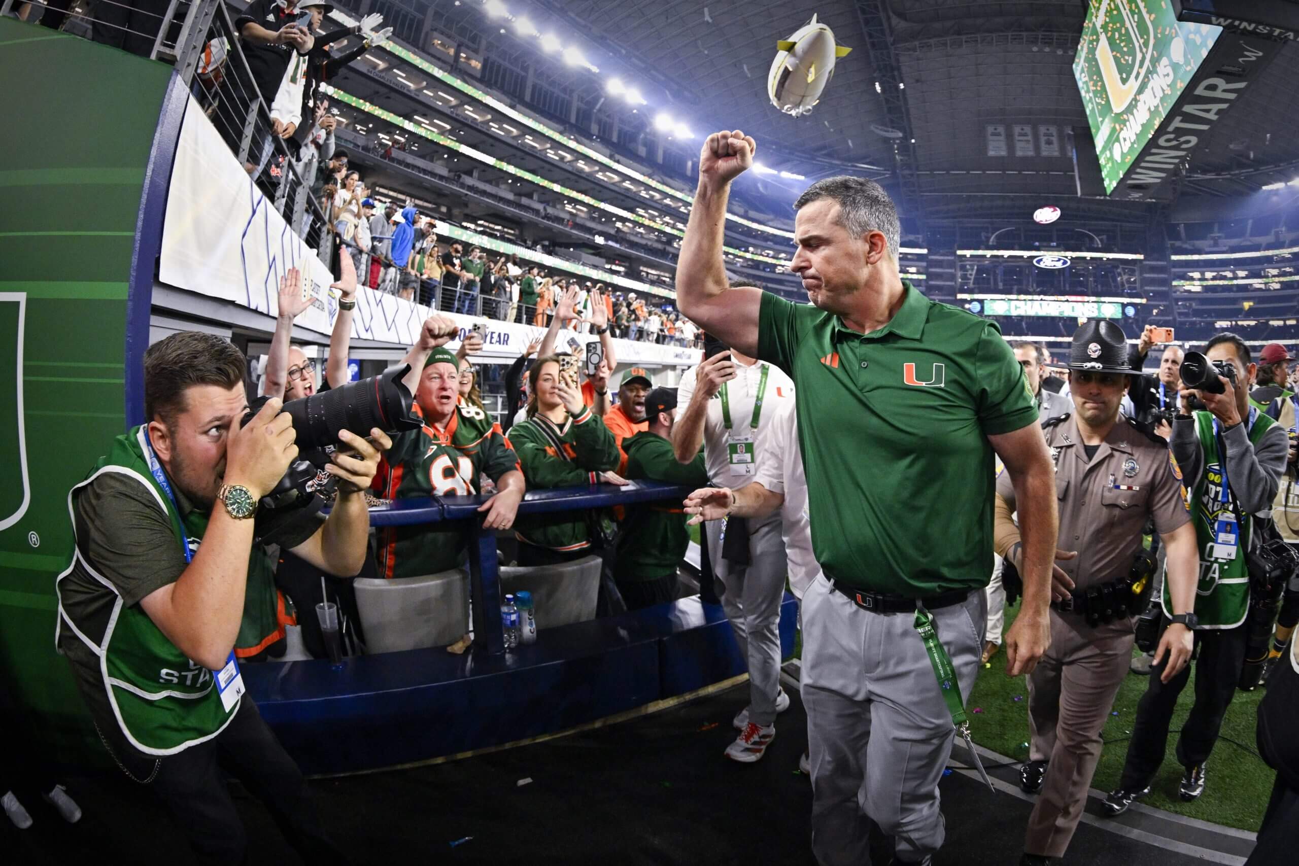 Miami coach Mario Cristobal pumps his first to fans while walking off the field after the Cotton Bowl