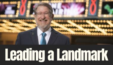 John Bell smiles outside Tampa Theatre beneath the historic marquee lights during an interview about his leadership and legacy.