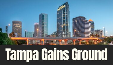 Downtown Tampa skyline at dusk with illuminated office towers and highway overpass as the city gains national recognition for corporate headquarters growth