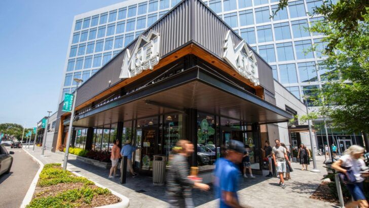 REI Co-op storefront at Midtown Tampa with pedestrians and office buildings in the background