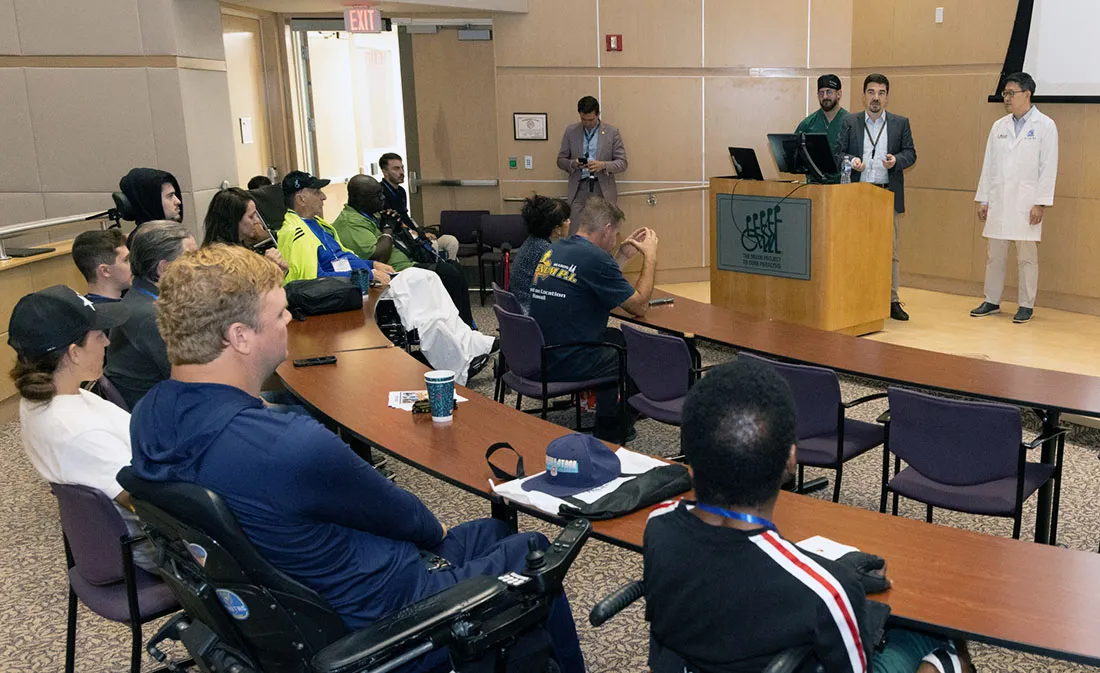 Dr. Matija Milosevic speaking from a podium at the group's open house
