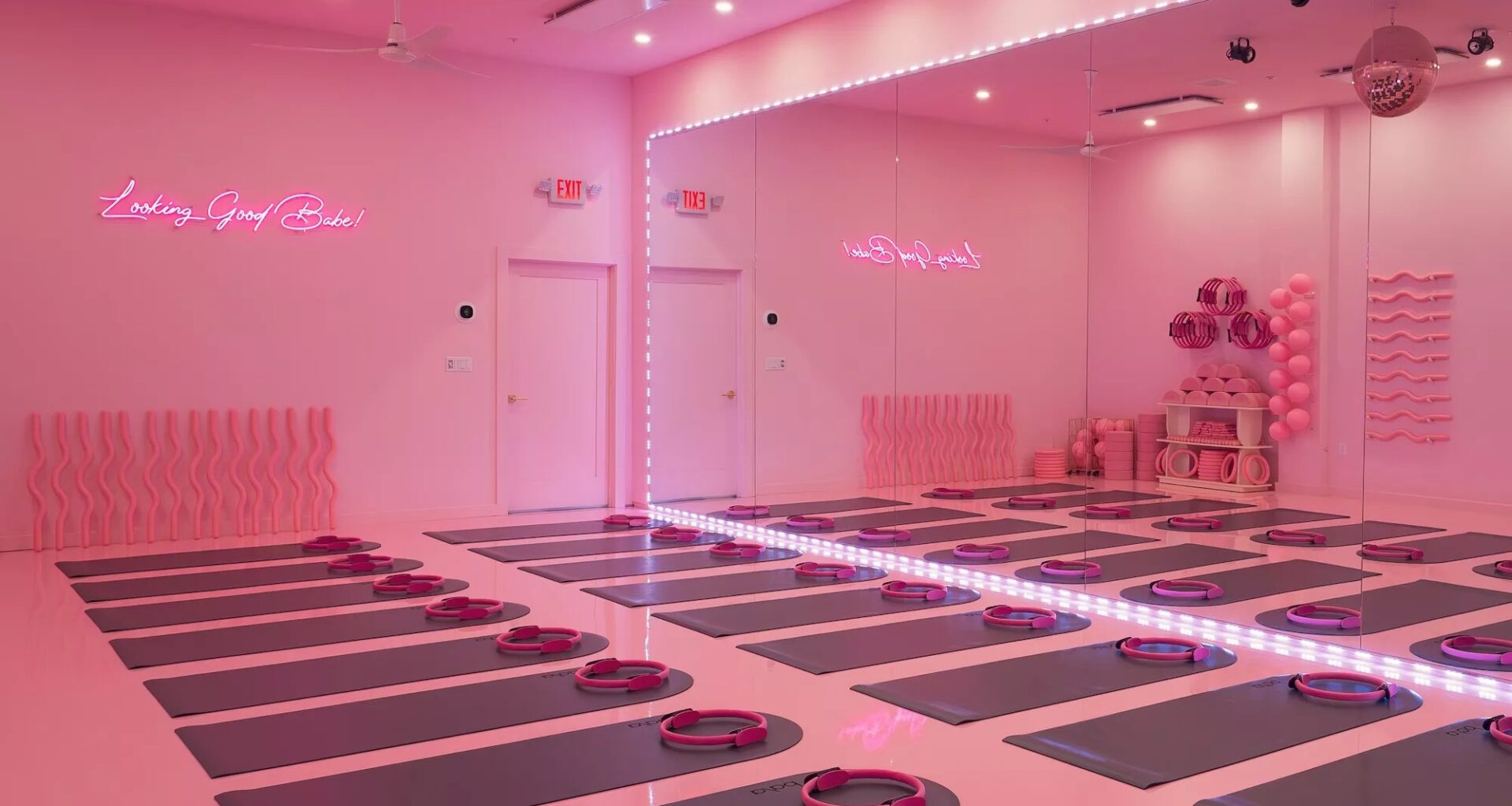 a studio lit in pink lighting with mats on the floor