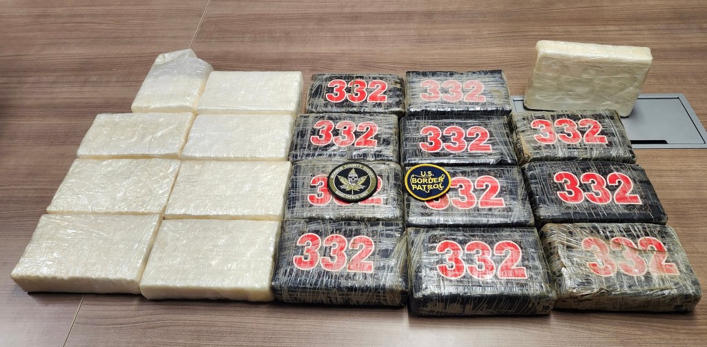 Blocks of cocaine on a wooden surface, with U.S. Border Patrol and Narcotics Unit patches.