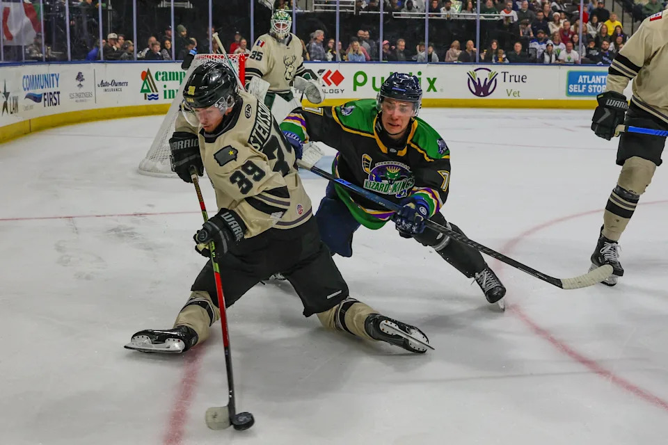 Iowa Heartlanders defenseman Alexander Stensson (39) advances the puck behind his back defended by Jacksonville Icemen forward Nathan Dunkley (7) in Saturday's game.