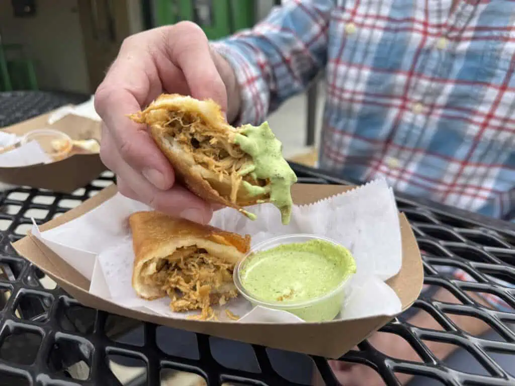 An empanada being dipped in sauce