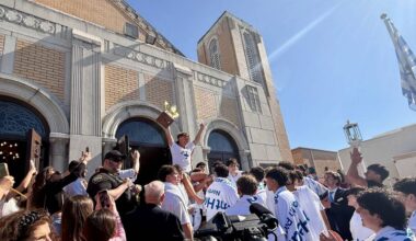After retrieving the cross thrown into the Spring Bayou for 2026 Epiphany, 18-year-old Athos Karistinos celebrates with other cross divers at St. Nicholas Greek Orthodox Cathedral. (Spectrum News/Virginia Johnson)