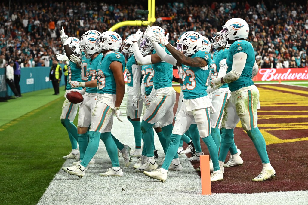 Miami Dolphins players celebrating a turnover from a punt during an NFL game.