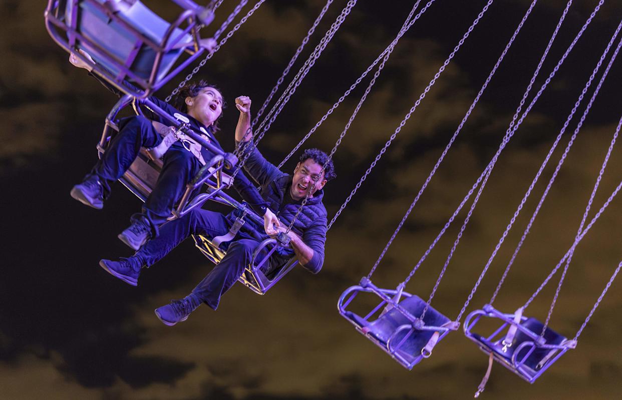 Harold Bernate and his son, Alec Bernate, 9, enjoy the flying swings.