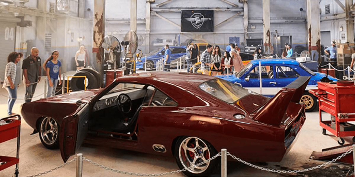 Multiple cars on display at the Fast and Furious Supercharged garage.
